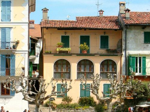 斯特雷萨Enticing Apartment in Stresa with Balcony Lake Views的黄色的建筑,设有绿色的门窗