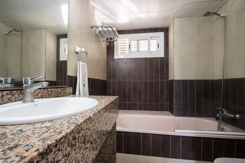 贝尼多姆托雷亚戈公寓酒店的浴室配有盥洗盆和浴缸。