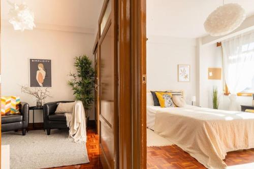 拉科鲁尼亚VibesCoruna - Outeiro 222的一间卧室配有一张床、一张沙发和一把椅子