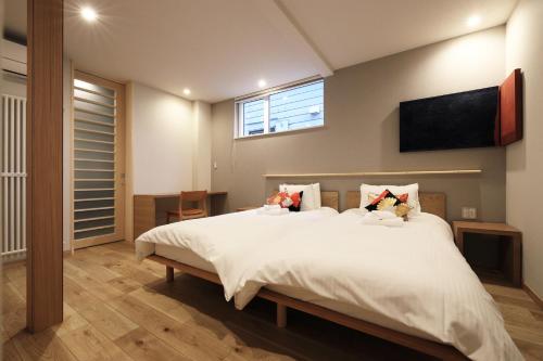 富良野AKATSUKI的卧室配有一张白色大床,上面有两只填充动物