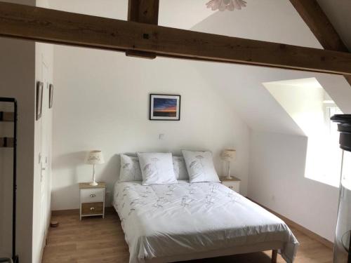 Bricqueville-sur-MerLe Bout du Monde的一间卧室配有一张带白色床单的床和一扇窗户。