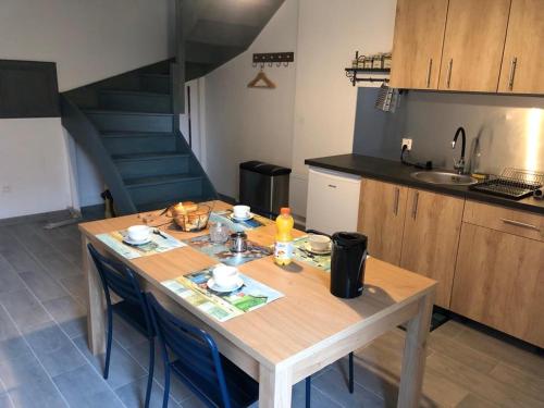 Bricqueville-sur-MerLe Bout du Monde的厨房配有木桌、椅子和楼梯