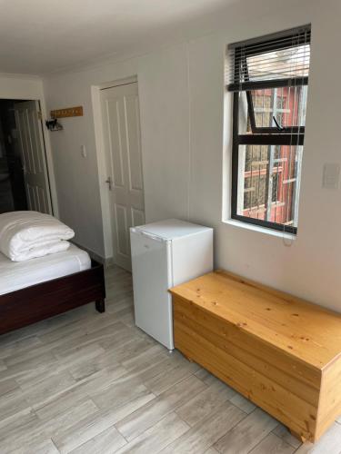 吕德里茨The Oasis Accommodation的客房设有床、书桌和窗户。