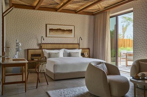 阿布扎比ERTH Abu Dhabi Hotel的一间卧室配有一张床、一张桌子和一把椅子