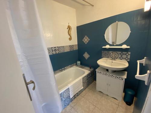 TautavelOs-thel, Chambres à louer的带浴缸、水槽和镜子的浴室