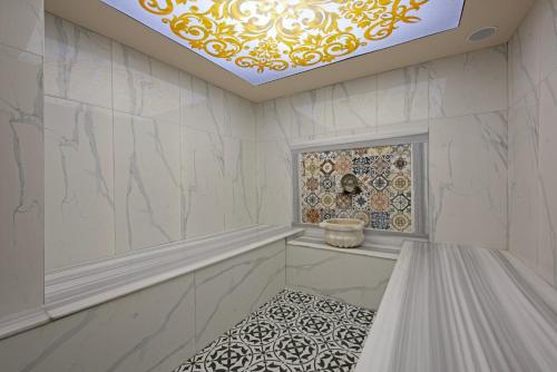 阿拉尼亚Büyük Hotel的一间拥有白色大理石墙壁和天花板的浴室