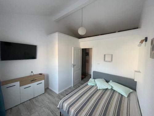 曼加利亚LaVoiLaNoi的卧室配有一张床,墙上配有电视。