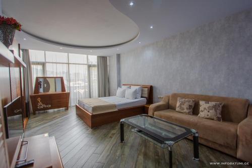 巴统Hotel Nica的带沙发、床和桌子的客厅