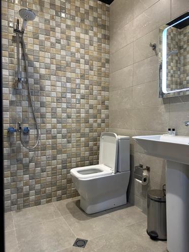 巴统Hotel Nica的浴室配有卫生间、盥洗盆和淋浴。