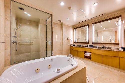 熊本日航熊本酒店的大型浴室设有浴缸和淋浴。