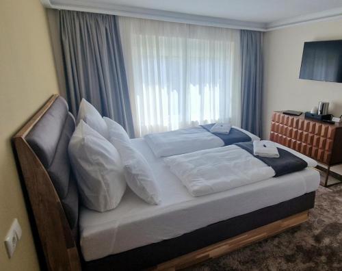 FehrbellinHotel Rhin Inn的卧室配有带白色枕头的床和窗户。