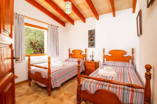 波连斯萨Can Vadell的一间卧室设有两张床和窗户。