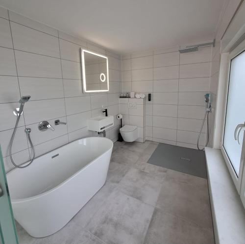 FehrbellinHotel Rhin Inn的白色的浴室设有浴缸和卫生间。