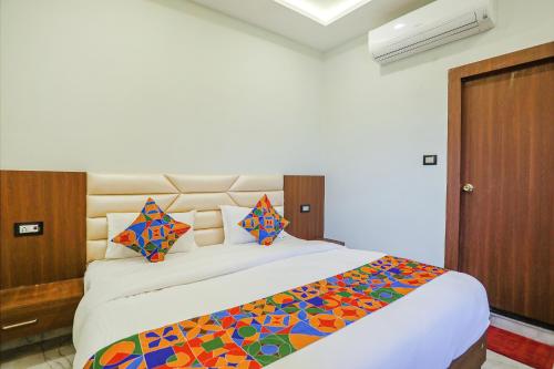勒克瑙FabHotel DDS的一间卧室配有一张大床和色彩缤纷的毯子