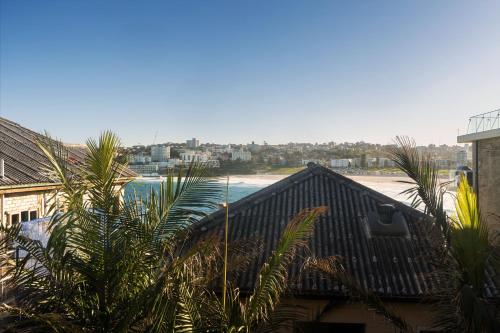 悉尼Sunlit 2BR Coastal Charm Bondi Beach Beach View的棕榈树房屋享有海滩美景