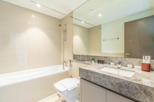 迪拜Lux BnB Act-1 Tower I Boulevard Views的浴室配有卫生间、盥洗盆和浴缸。