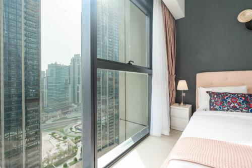 迪拜Lux BnB Act-1 Tower I Boulevard Views的一间卧室设有一张床和一个大窗户