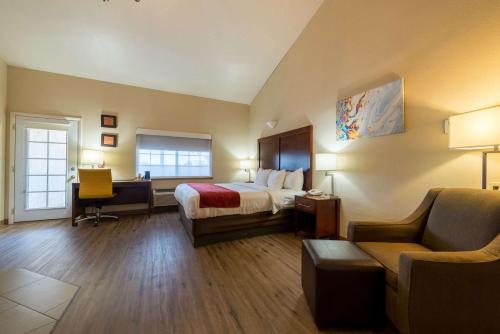 阿拉莫萨Comfort Inn & Suites Alamosa的酒店客房配有一张床、一张桌子和一把椅子。
