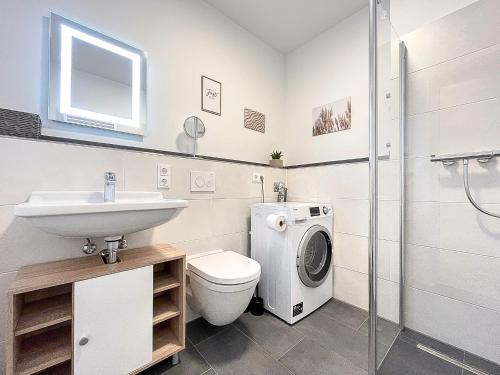 博尔滕哈根Weiße Villen Wohnung 20的浴室配有卫生间水槽和洗衣机。