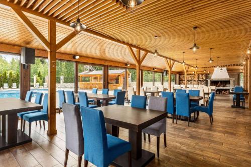 班斯科The Balkan Jewel Resort, Trademark Collection by Wyndham的一间配备有桌子和蓝色椅子的用餐室