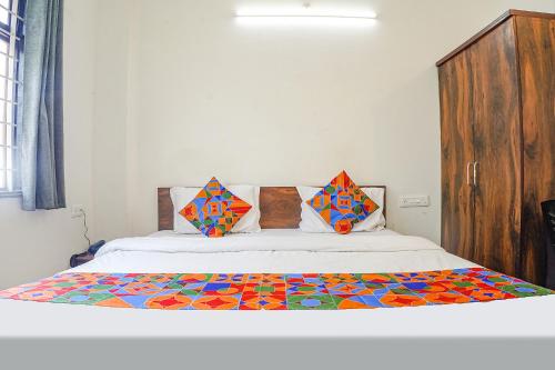博帕尔FabExpress SSG的一间卧室配有一张带五颜六色棉被的床