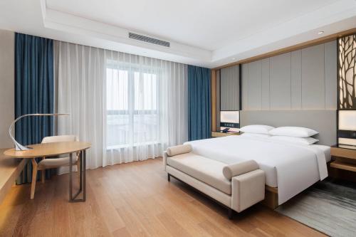 杭州杭州西溪万怡酒店的卧室配有白色的床、桌子和椅子