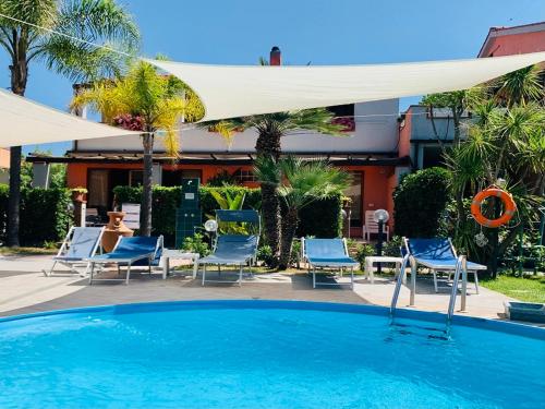 坎普码头Hotel Elba的一个带蓝色椅子和白色遮阳伞的游泳池