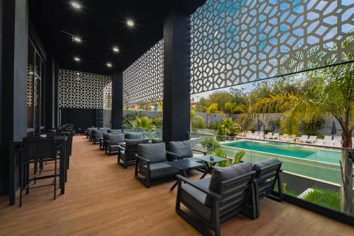 阿尔及尔AD HOTEL HYDRA的酒店大堂设有椅子和游泳池