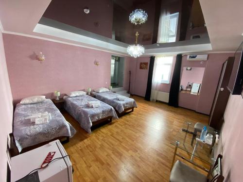 乌尔根奇HOTEL UZBEGIM的配有粉红色墙壁和木地板的客房内的两张床