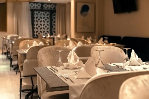 阿尔及尔AD HOTEL HYDRA的用餐室配有桌椅和餐巾