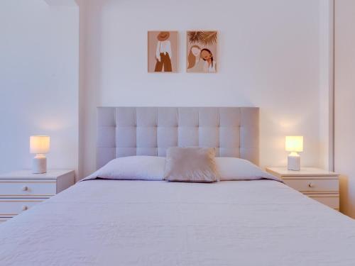 奎特里拉AL - Apartamento Quinta do Romão的一间卧室配有一张带两盏灯的大型白色床。
