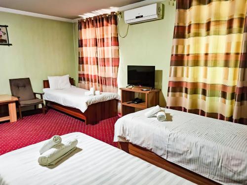 KokandReikartz Kokand的一间酒店客房,设有两张床和电视