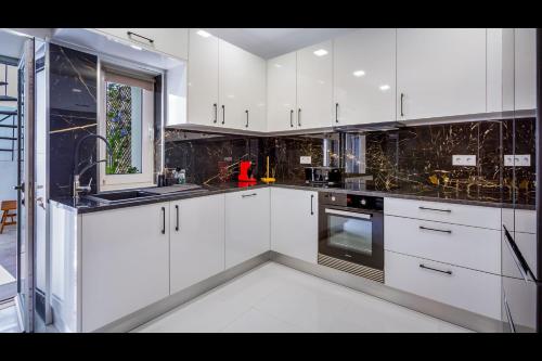 西尔韦斯Stunning Flat With Jacuzzi in Silves by LovelyStay的厨房配有白色橱柜、水槽和炉灶。