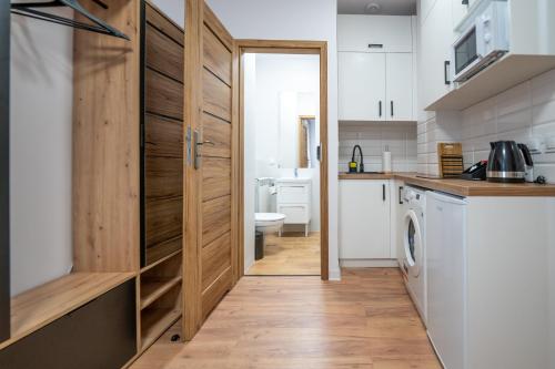 波兹南Apartamenty Słowackiego 16的厨房设有木门、洗衣机和烘干机。