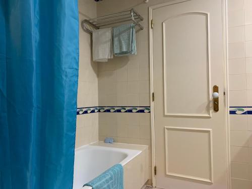 维拉摩拉Discovery Apartment Vilamoura的一间带浴缸的浴室和一扇白色门