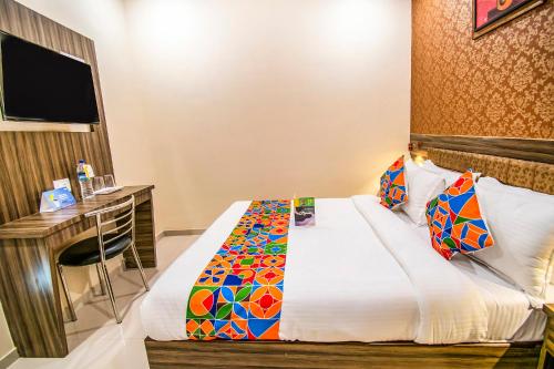 孟买FabExpress Orange Suite的配有一张床和一张书桌的酒店客房