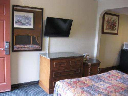 圣贝纳迪诺阳光汽车旅馆的酒店客房设有床、梳妆台和电视。
