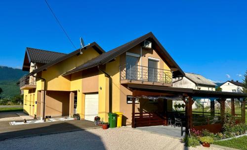 科雷尼察Sweet Dreams Home的大型黄色房屋设有门廊和阳台