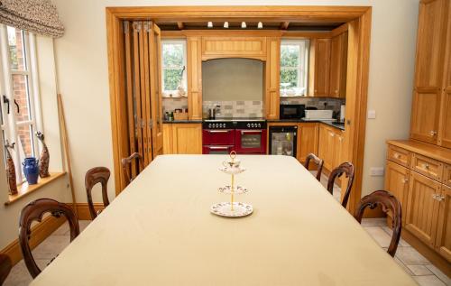 威勒尔Mere Brook House的厨房配有长桌和椅子