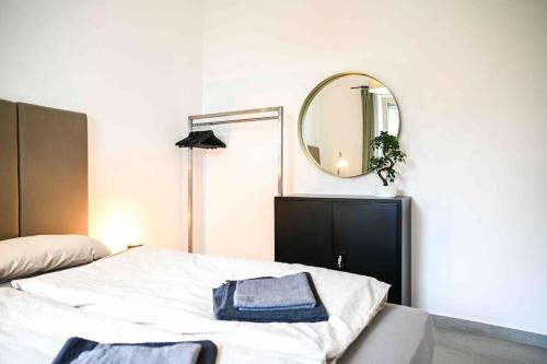 柏林Moderne Wohnung in Ruhiger Umgebung nahe Messe的卧室配有一张带镜子的白色床