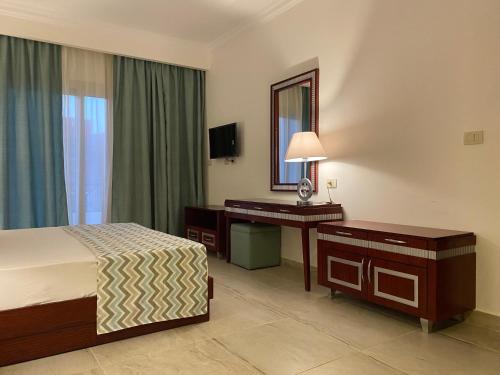 阿布达巴Oyster Bay Marsa Alam (unit I6-13)的酒店客房带一张床、一张书桌和一面镜子