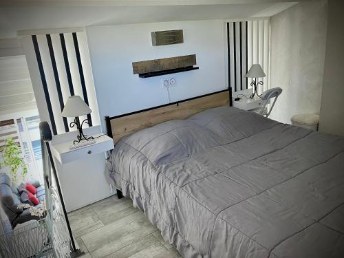 阿格德角Naturiste Heliovillage Villa de Standing的一间卧室配有一张床、两张桌子和两盏灯。