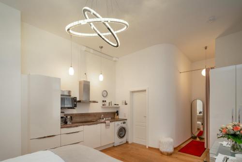 巴登-巴登Comfort Apart Baden-Baden的厨房配有白色橱柜和吊灯。