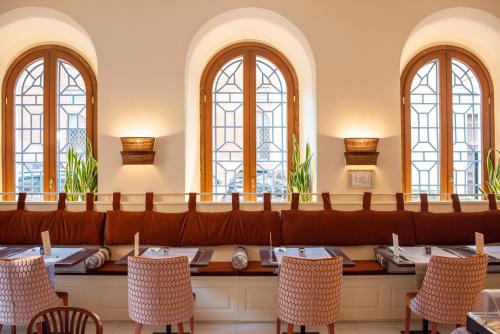 罗马Sentho Roma的用餐室设有桌椅和窗户。