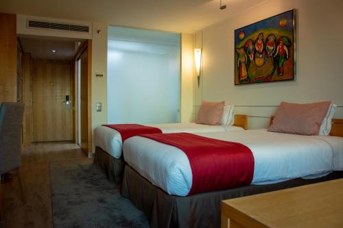 里斯本VIP Executive Entrecampos Hotel & Conference的酒店客房,配有两张带红色床单的床