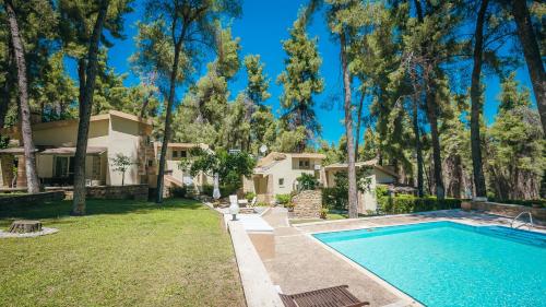 撒尼海滩Sani Cape Shared Pool Villas的一座带游泳池和树木的房子