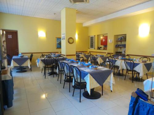 斯培西亚玛丽酒店的一间设有桌椅的房间,配有蓝色和白色的桌布