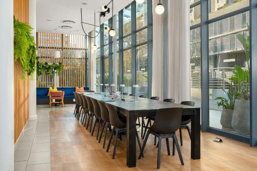 开普敦Neighbourgood Newlands的一间用餐室,配有黑色的桌子和椅子