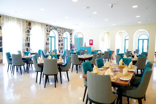 富查伊拉Dibba Mountain Park Resort的用餐室设有桌椅和窗户。