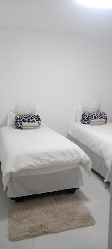 OkakararaEsteem Guesthouse的两张睡床彼此相邻,位于一个房间里